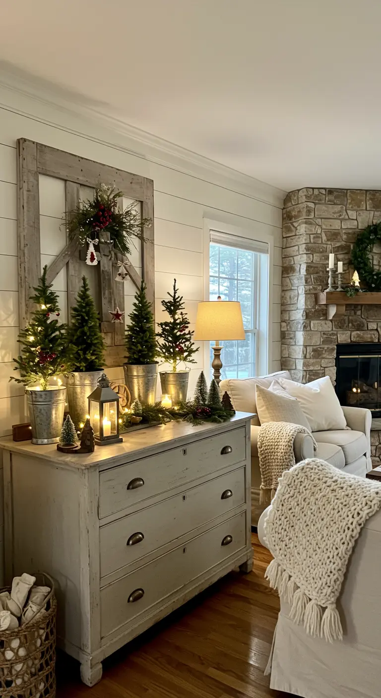 Commode rustique avec mini-sapins lumineux dans des seaux en zinc et une lanterne.