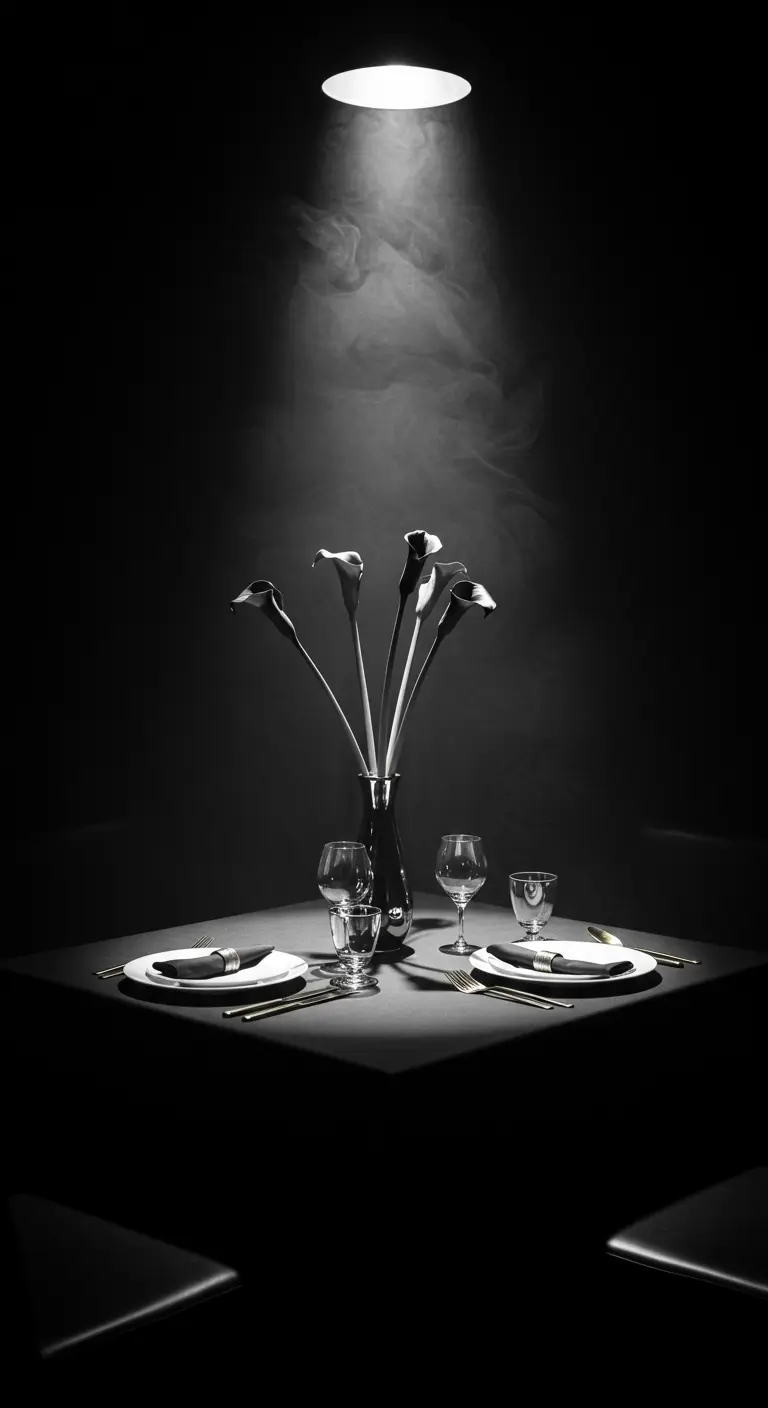 Table minimaliste dans le noir, éclairée par un unique spot venant du dessus.
